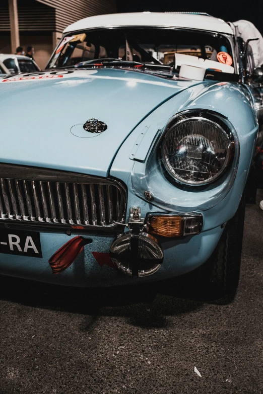 an old car sits parked with other classic cars in the background