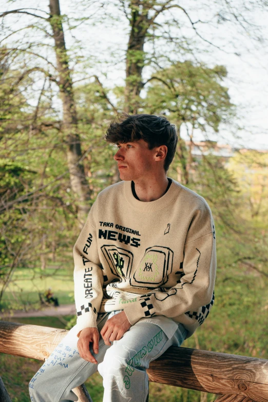 the boy is sitting on the log outside with his pants open