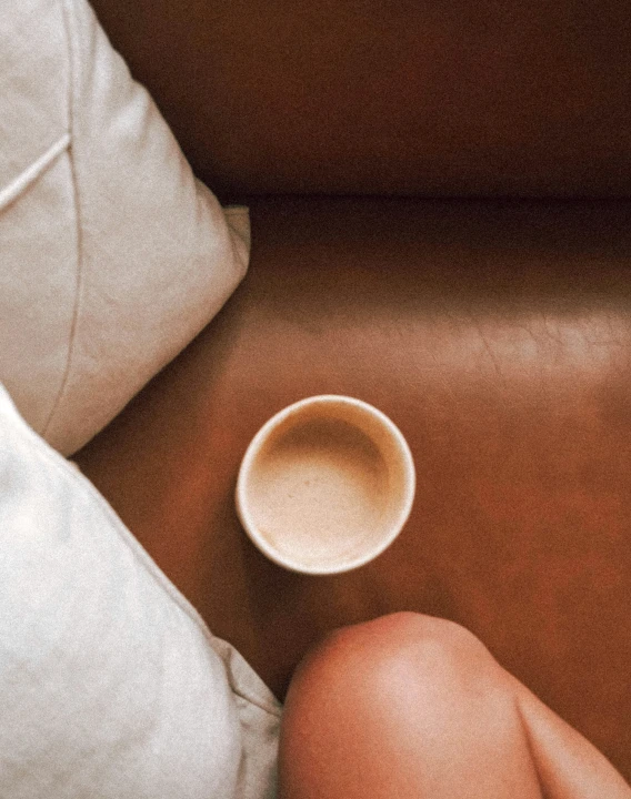 a  woman in lingerie with her legs crossed and a coffee mug