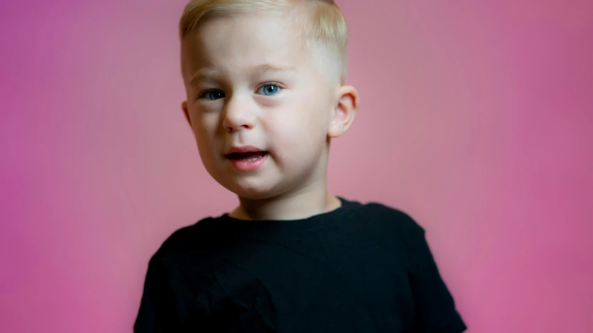 a little boy with blond hair posing for a picture