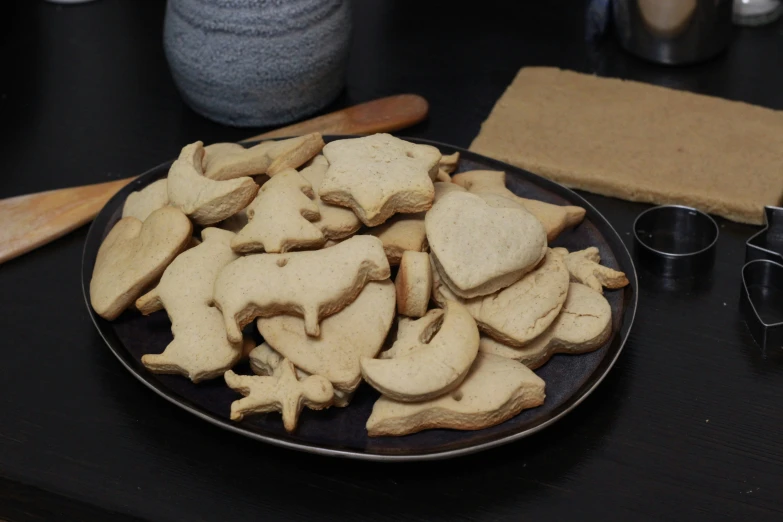 some cookie biscuits next to some baking utensils