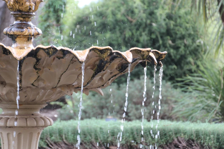 the fountain is spraying water in a park