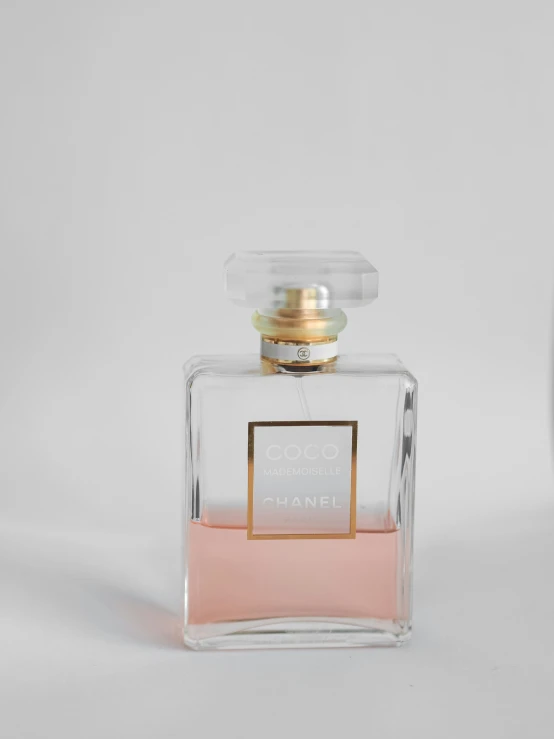 an empty bottle of perfume sitting on a white surface