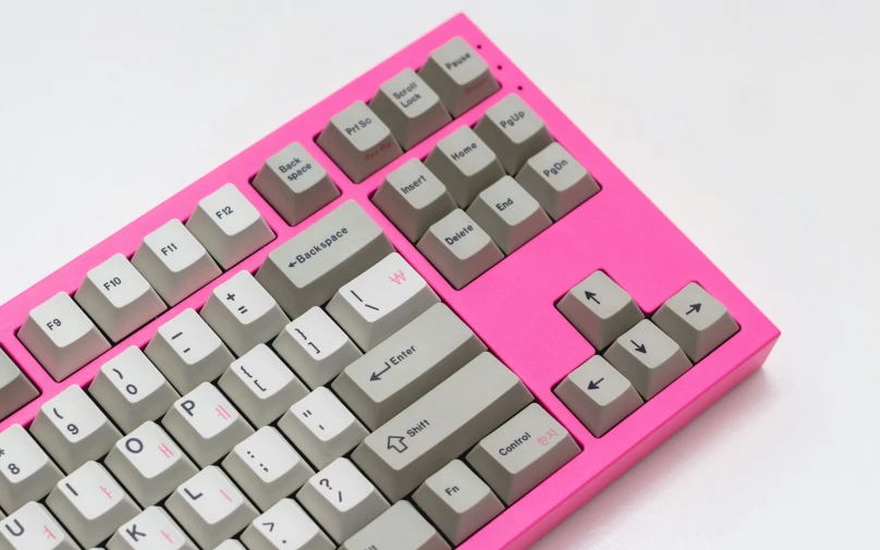 a close up of a keyboard in pink on a white background