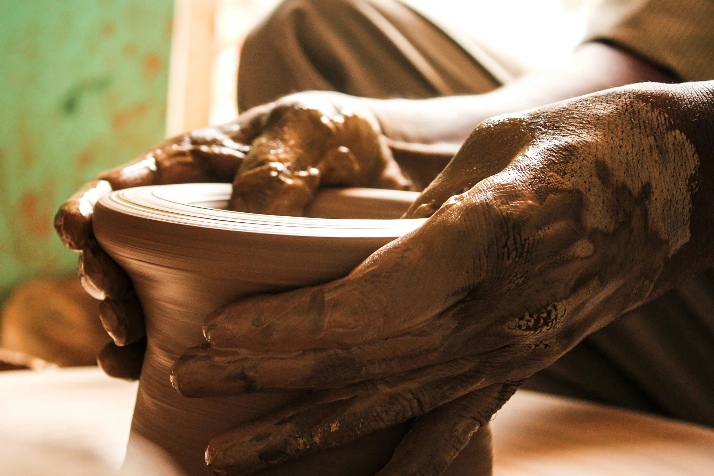 a person holding a pottery pot with their hands