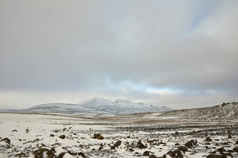 landscape with snowy mountains and rocks and cloudy sky