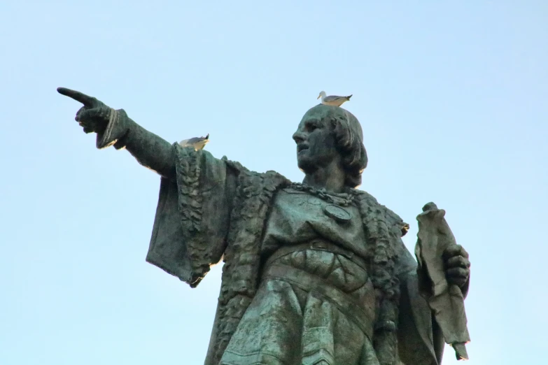 statue with two birds on it's shoulders pointing to the right