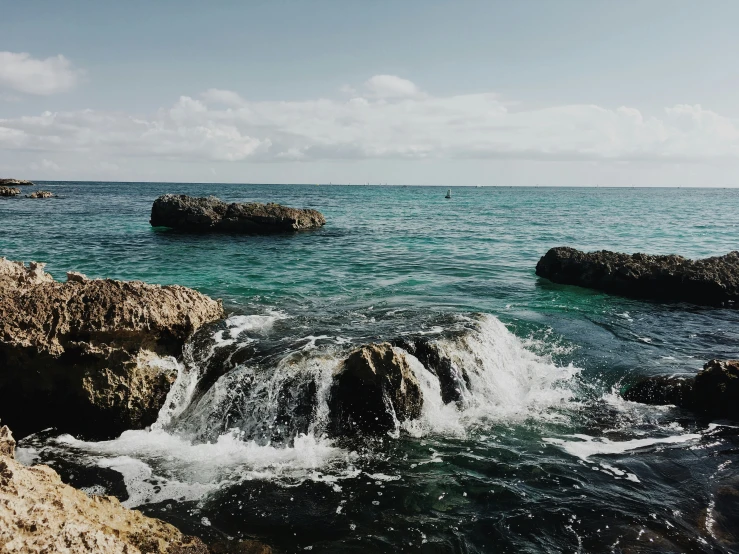 a rocky beach with small boulders over a body of water