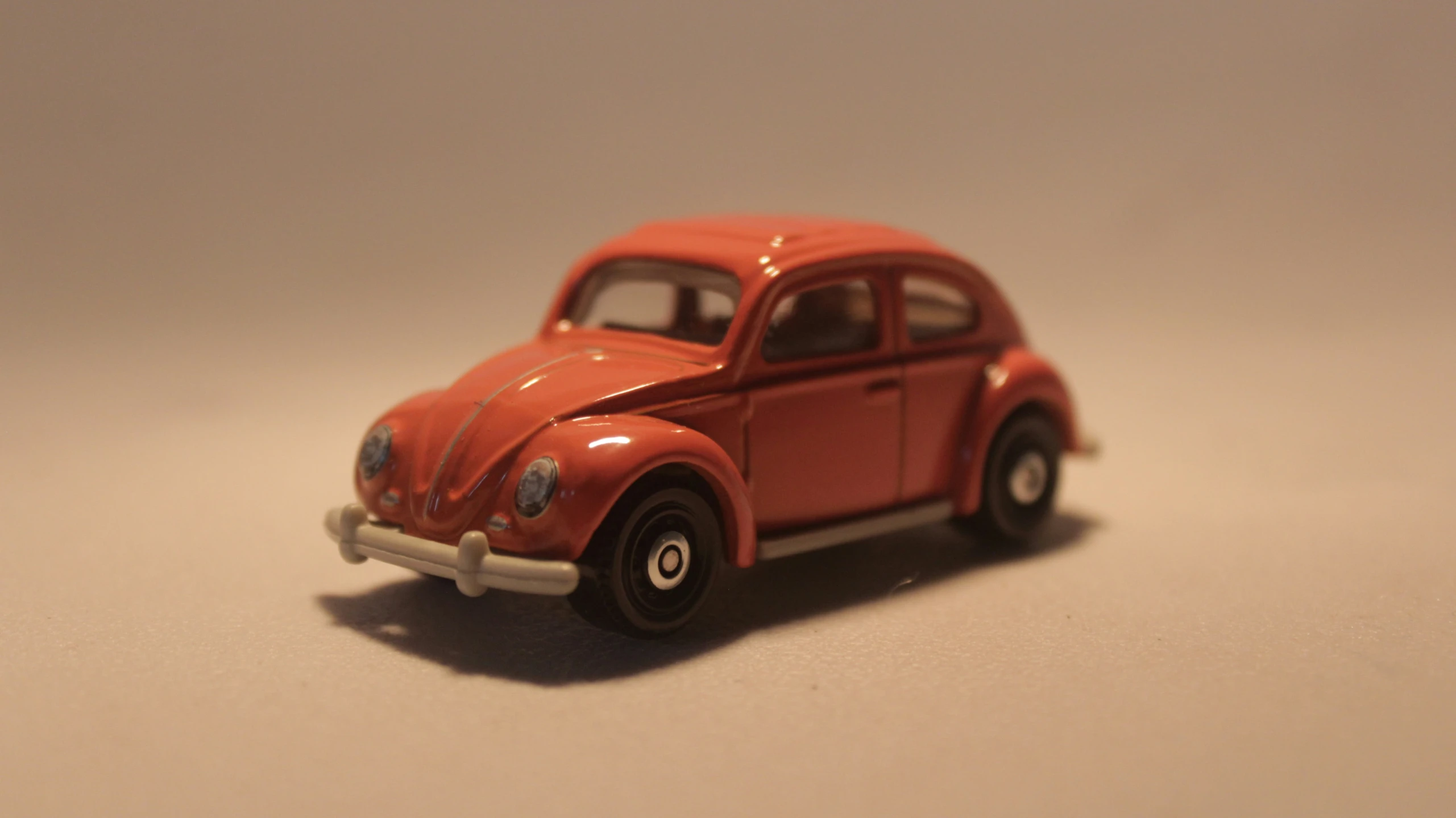 an old model of a red car that is painted orange