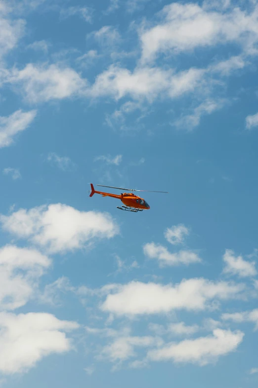 a helicopter flying high in a cloudy sky