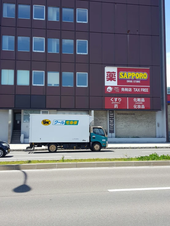 a truck parked outside of a building next to a street