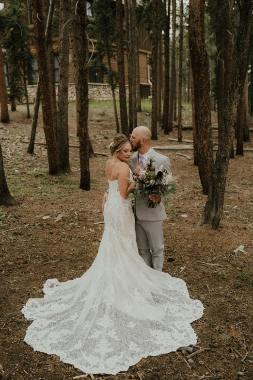 a bride and groom emcing in the woods