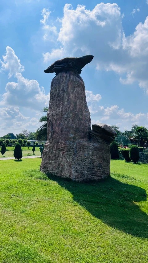 a giant stone chimney sitting on top of a grass field