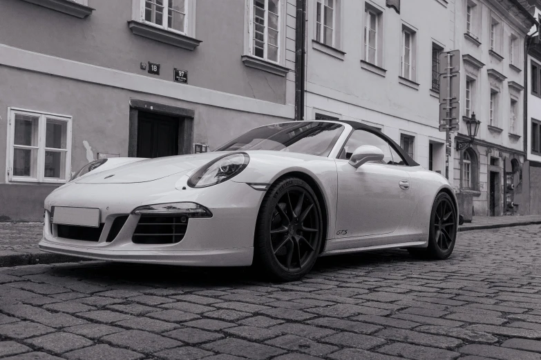 a white porsche parked on the side of a street