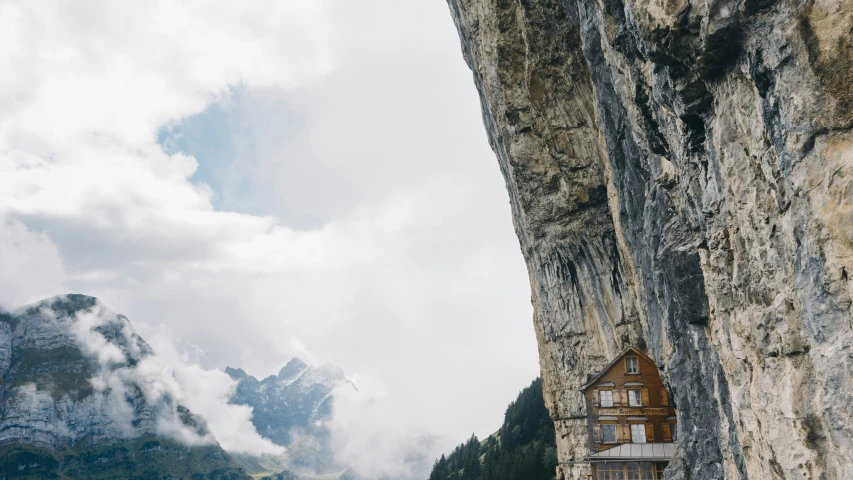 the building is hanging upside down on the mountain