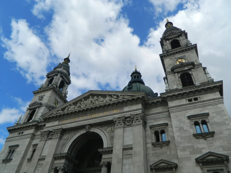 two towers stand above a large church and clock tower