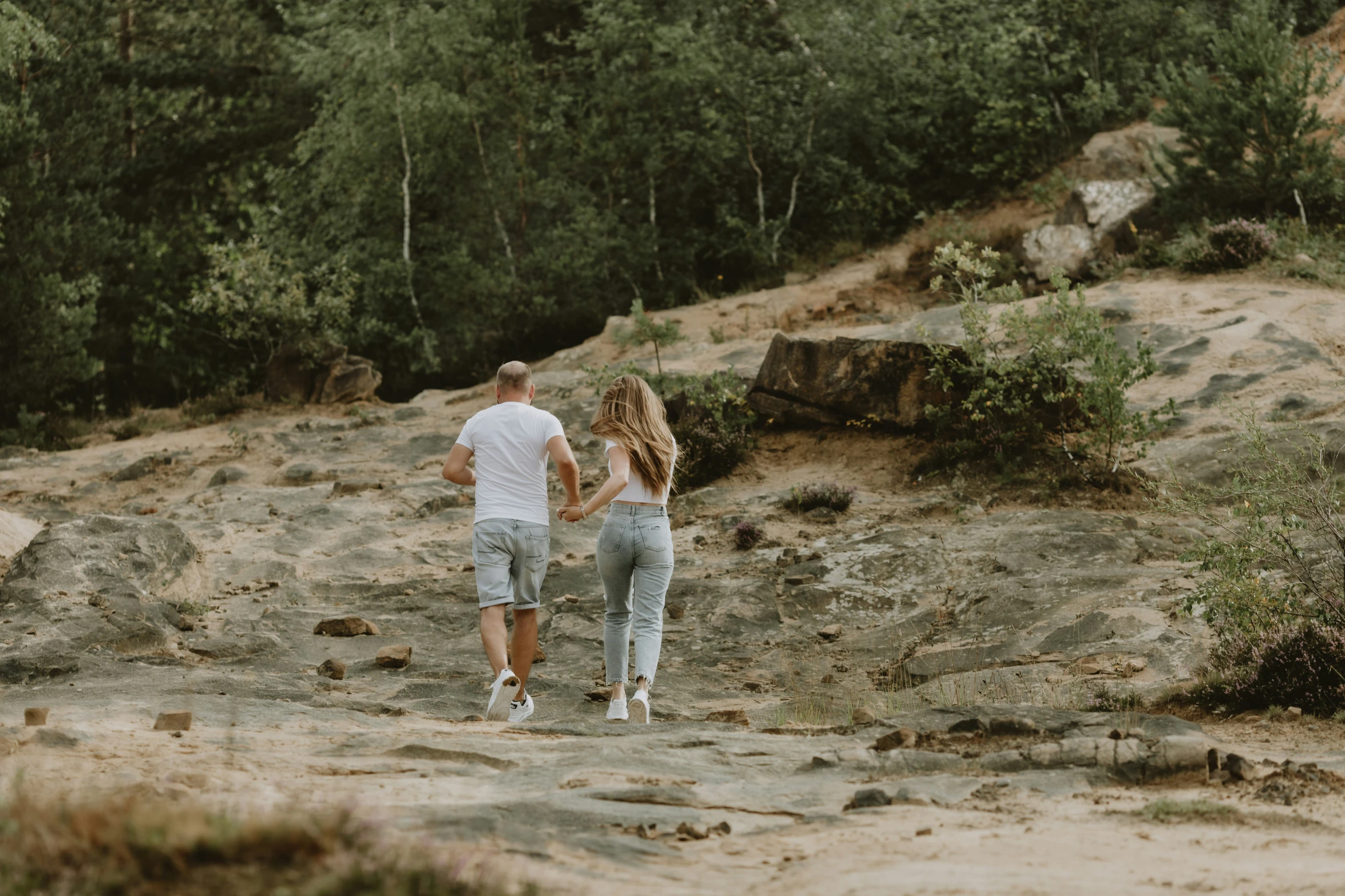 the young couple are holding hands on the sand