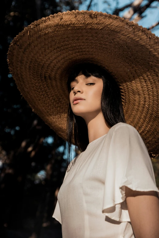 a woman wearing a large brown straw hat