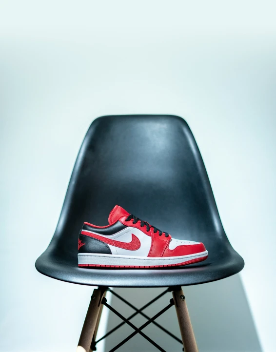 an orange and white sneakers on top of a black chair