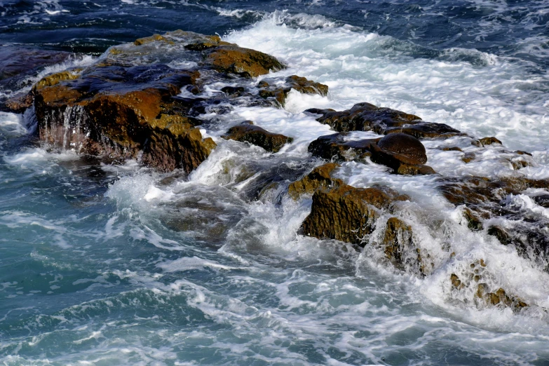 rocks covered with water are pictured close to the shore