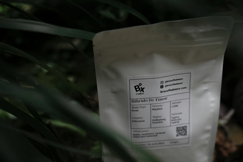 the bag of white powder sits near some plants