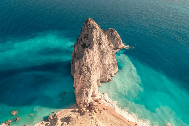 an aerial view of a rocky coastline and crystal blue waters