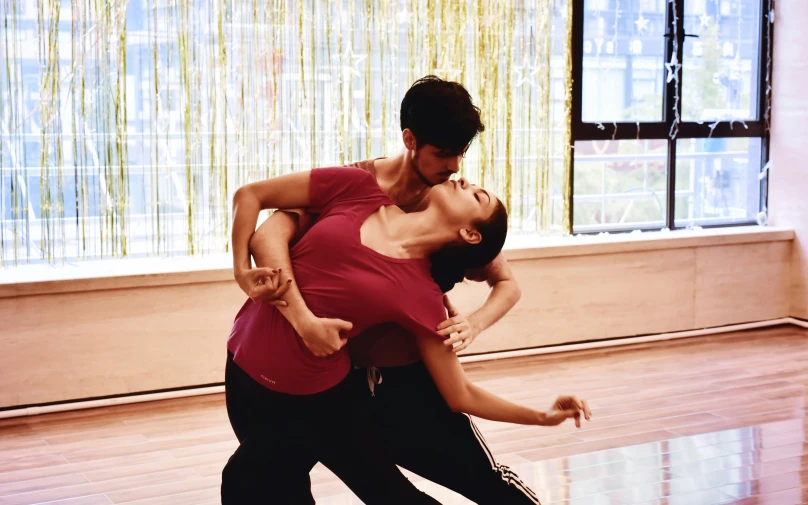 two people dance on an open floor floor