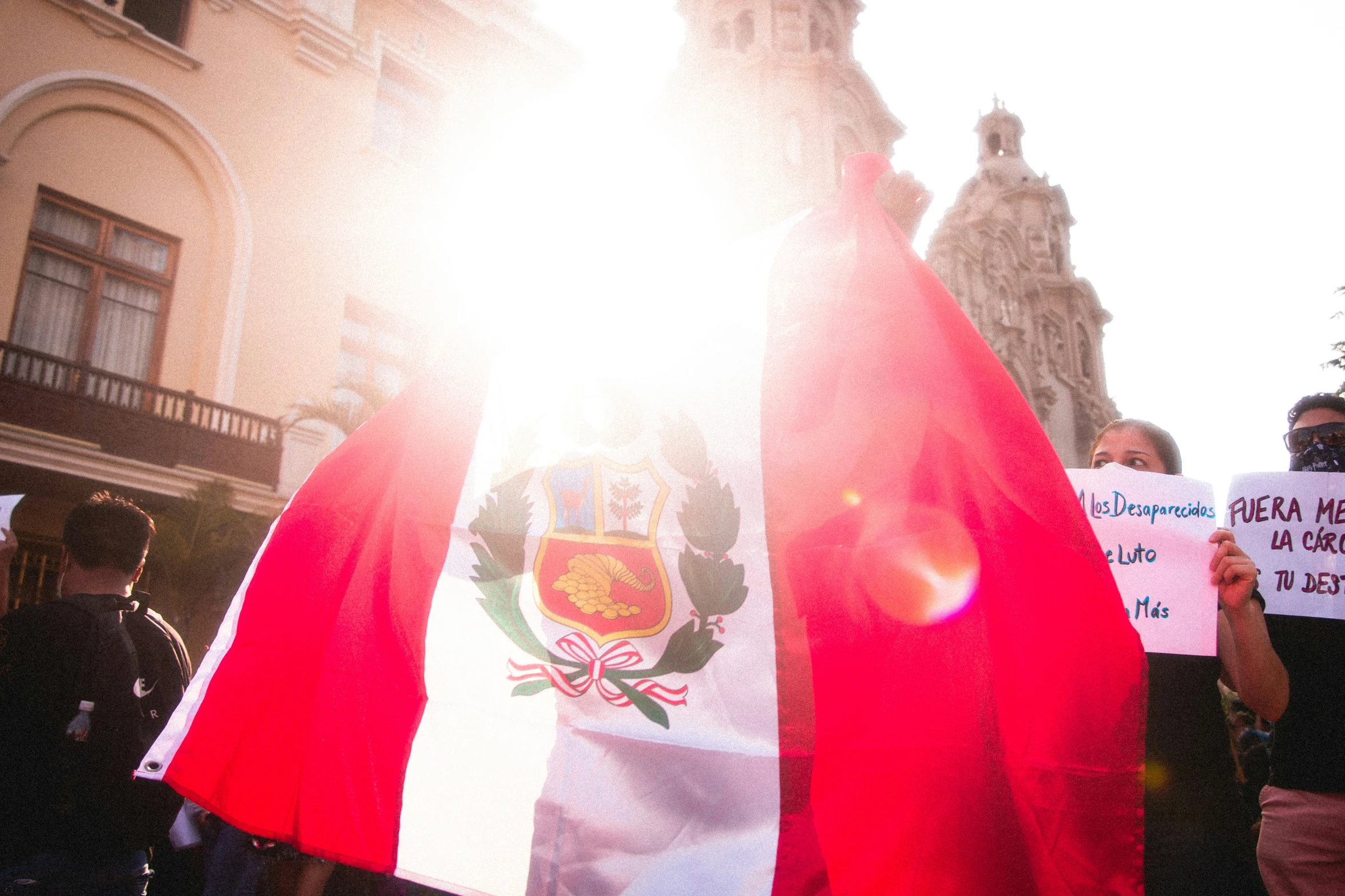 people are holding flags and standing outside of a building