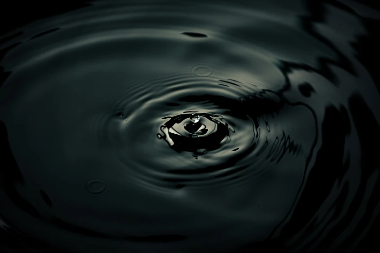 a drop in a black pond of water