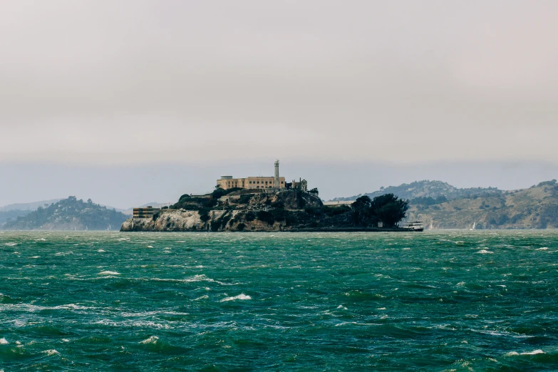 an island surrounded by sea water near some hills