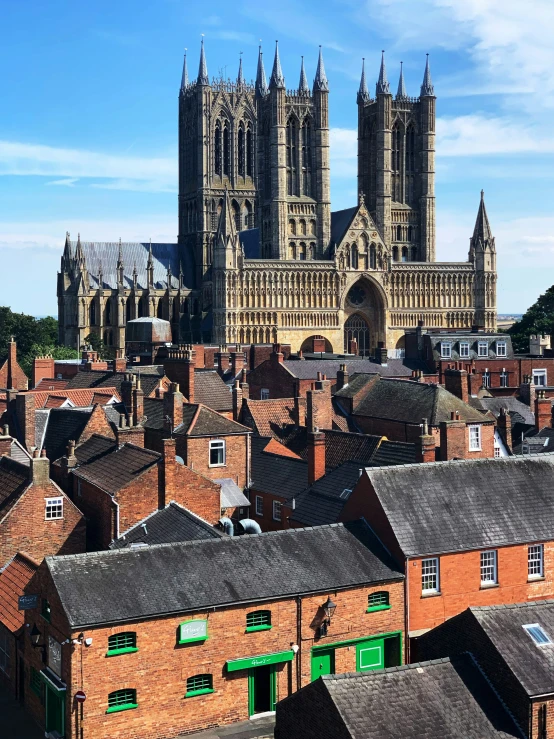 a church tower stands over the rooftops of old buildings