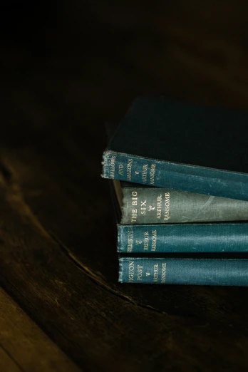 a stack of blue books on a wooden surface