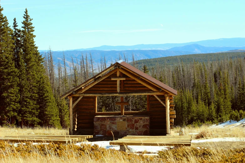 a shelter made of wood sitting in a field