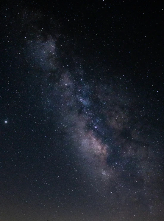 a beautiful view of a group of people with their backs turned to look up at the night sky