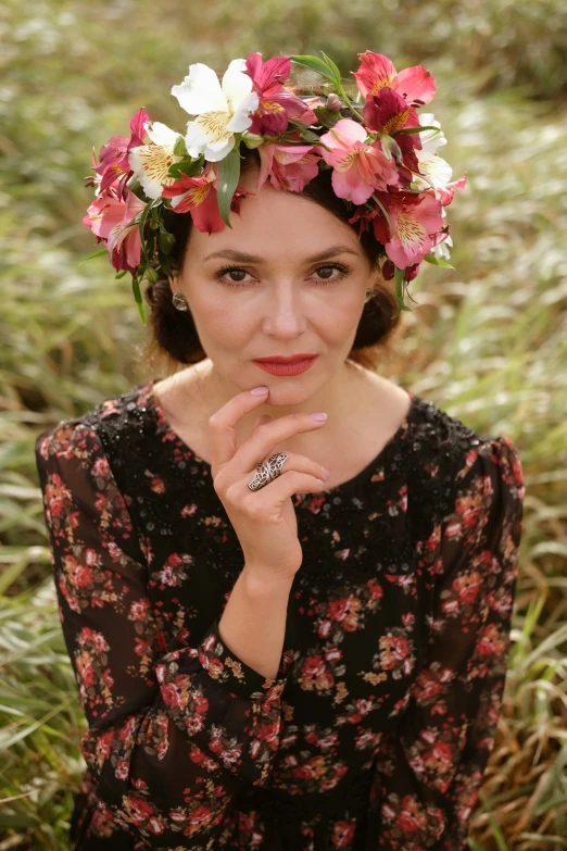 a woman with flower crown poses on the ground