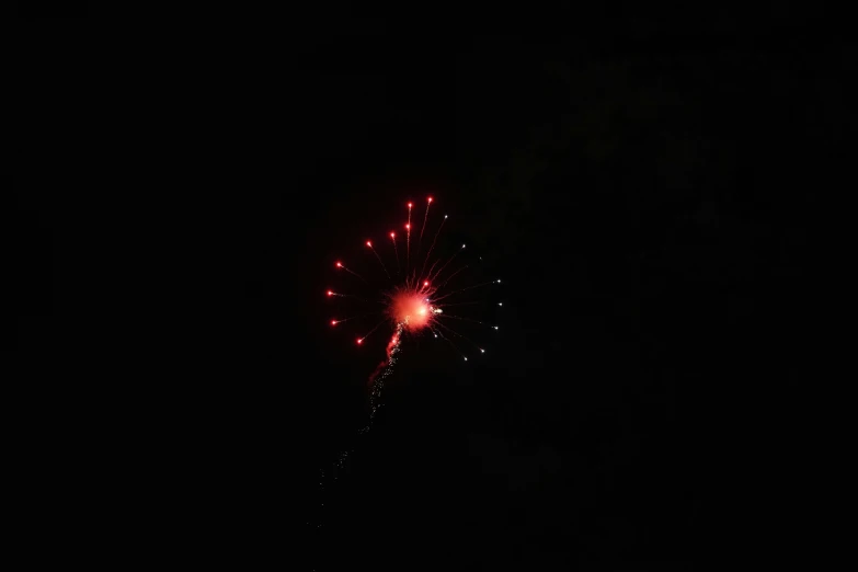 fireworks in the night sky with one light on