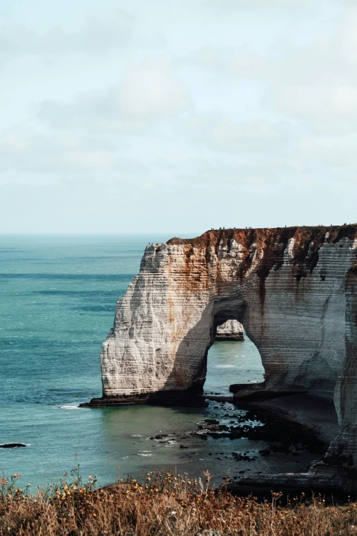 there is a large arch over looking the ocean