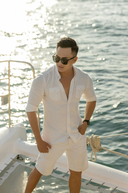 a young man standing on the edge of a boat in his bathing suit