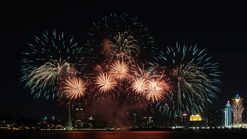 fireworks over the water in the night sky