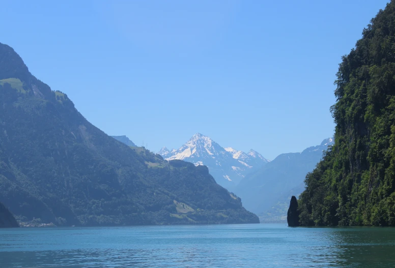 the water near the mountains has a boat in it