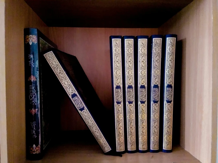 three books on the shelf are placed in an empty box