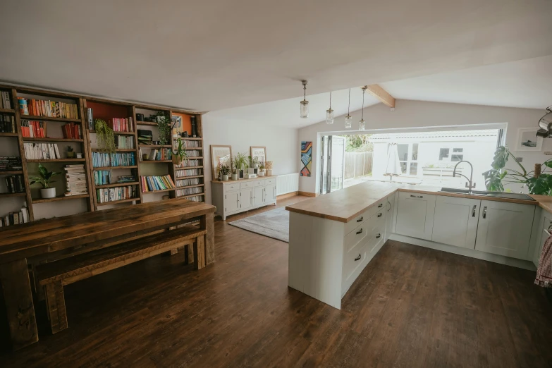 a kitchen with lots of wooden flooring and large windows