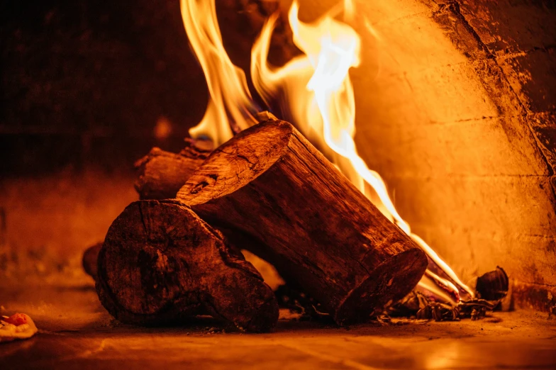 logs burn brightly in a fire with flames