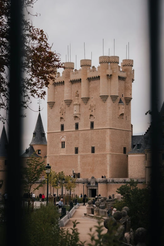 an old castle sitting outside with towers and flags on it