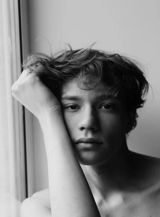an image of a shirtless boy with his hands in his hair