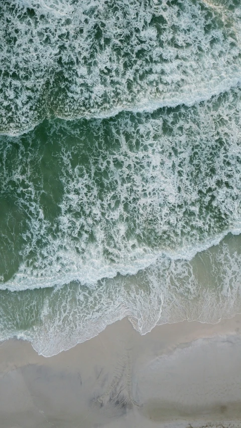 a sandy beach surrounded by water and clouds