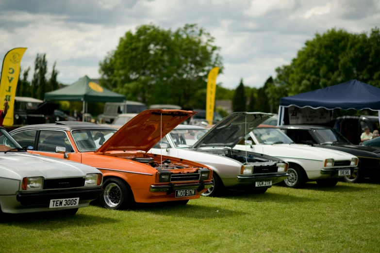 a couple of cars parked next to each other on a grass field