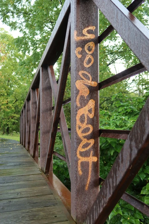 a bridge with graffiti written on it and some trees behind