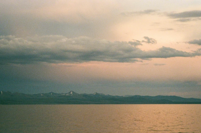 large body of water under dark skies with a few clouds