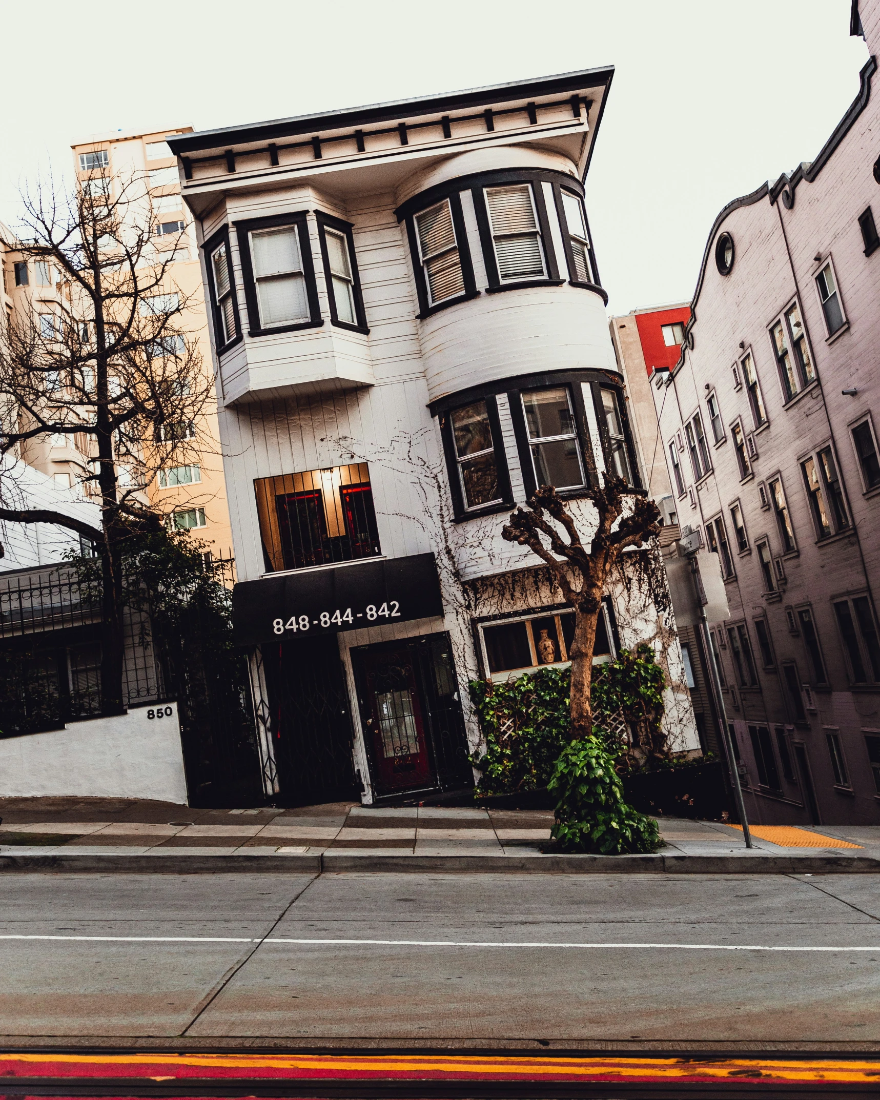 the street in front of some buildings has cars driving by